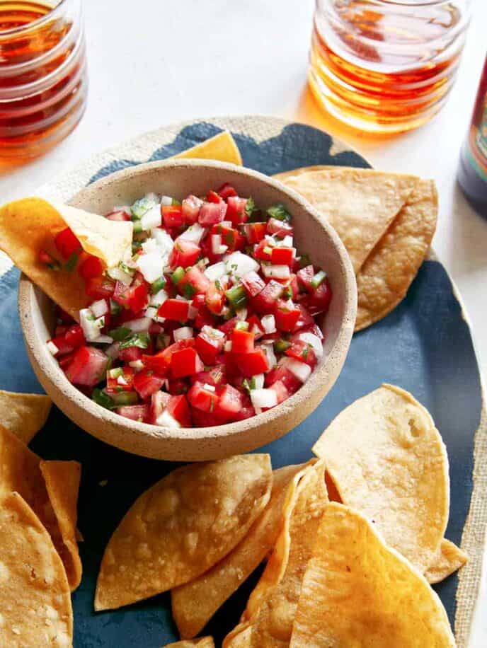 Pico de gallo recipe with some beers in the background.