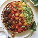 Heirloom tomato tart on a plate with fresh basil.