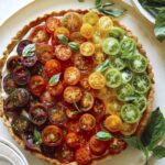 Heirloom tomato tart on a plate with fresh basil.