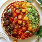 Heirloom tomato tart on a plate with fresh basil.