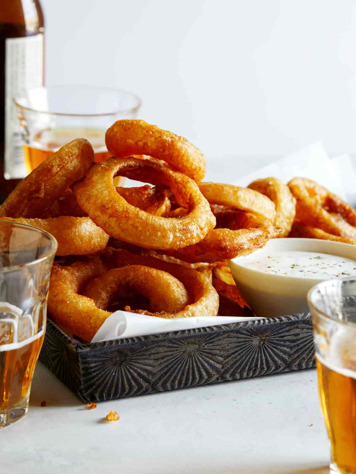 A tower of beer battered fried onion rings recipe with beer on the side. 