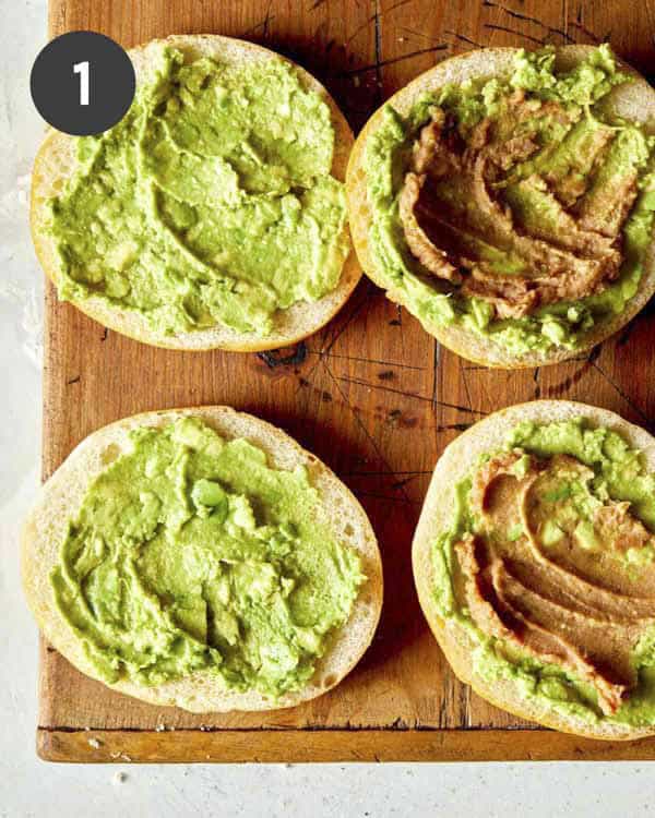 Mashed avocado and refried beans on Telera rolls to make a torta.