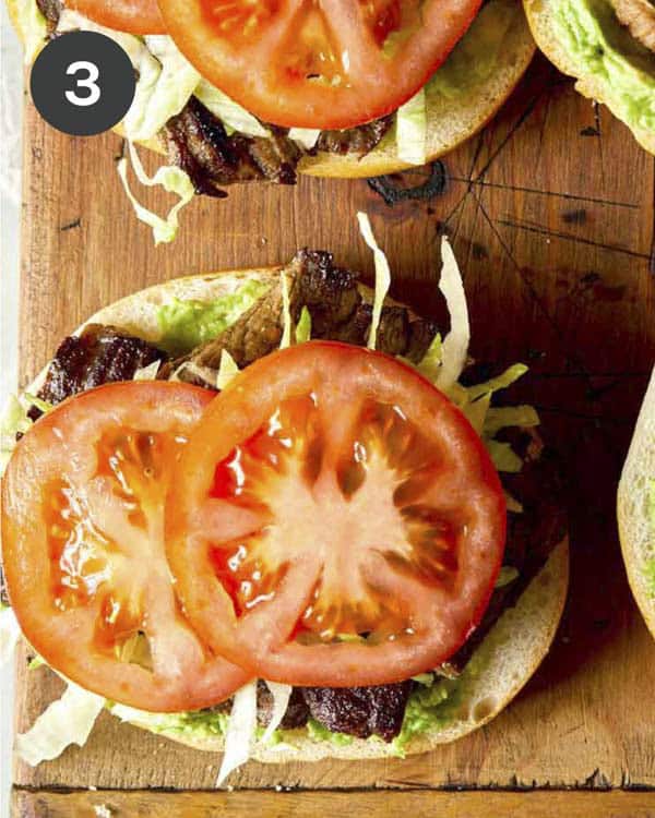 Toppings being added to a carne asada torta.