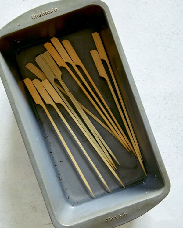 Skewers soaking in water for lamb kabobs.