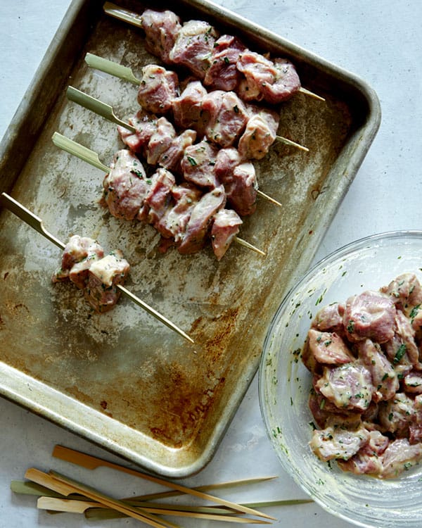 Skewering lamb kabobs to prepare them to grill. 