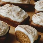 Pumpkin Bars with one cut in half on parchment.