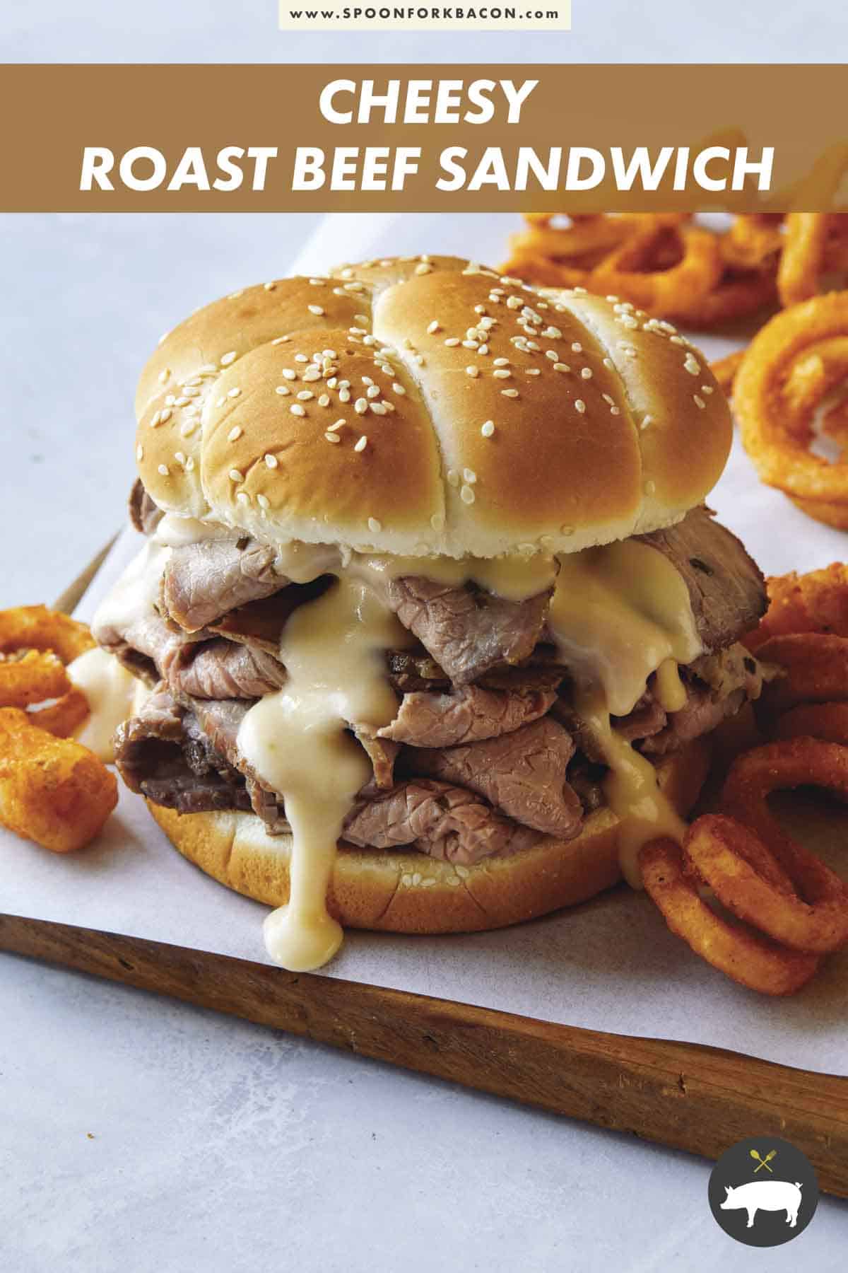 Roast beef sandwich with cheese on a cutting board.