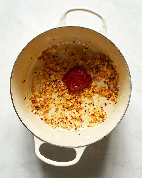 Onions and tomato paste in a stock pot. 