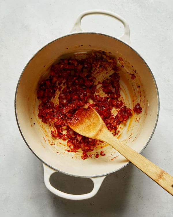 Tomato paste and onions in a stock pot to make arrabiata sauce.