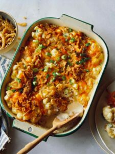 Creamy cauliflower bake recipe in a dish with some served onto a plate.