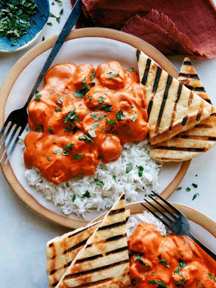 Butter chicken, or murgh makhani recipe on two plates with rice.