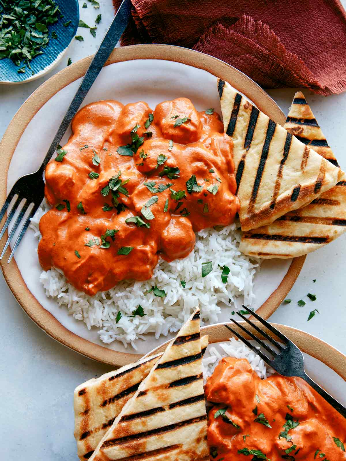 Butter chicken, or murgh makhani recipe on two plates with rice. 