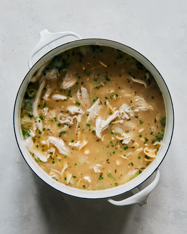 Chicken noodle soup in a stock pot cooking. 