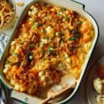 Creamy cauliflower bake recipe in a dish with some served onto a plate.