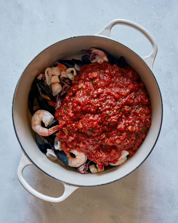 Frutti di mare in a pot about to be stirred together.