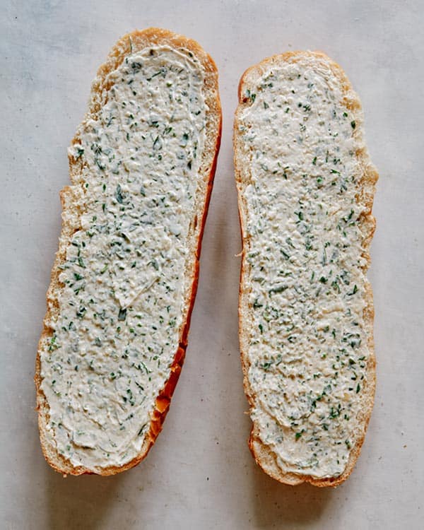 Garlic bread butter spread onto bread ready to go into the oven.