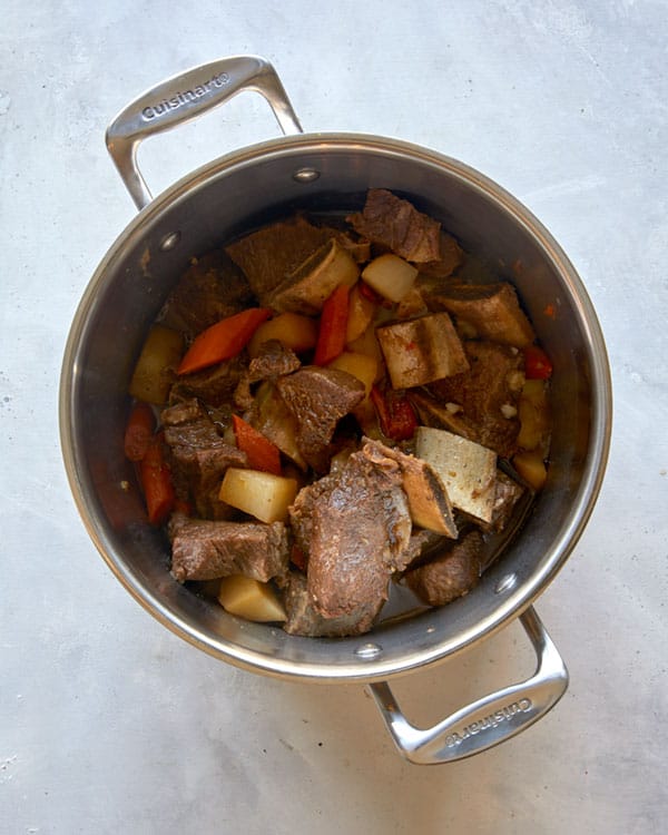 Short ribs in a pot with vegetables cooking to make Galbi Jjim.