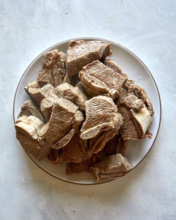 Freshly cooked short ribs resting on a plate.
