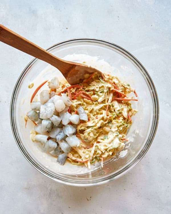 Adding shrimp to okonomiyaki batter.