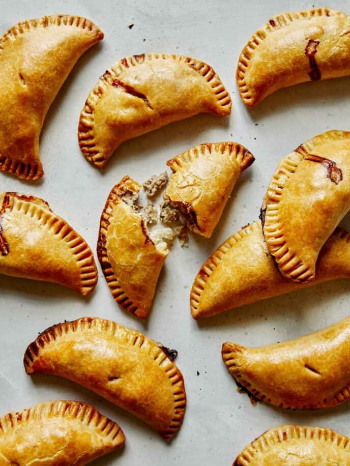 A bunch of pork pasties on a surface. 