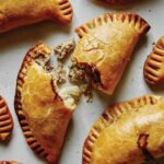A bunch of pork pasties on a surface.