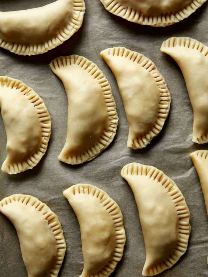 Pork pasties on a baking sheet.