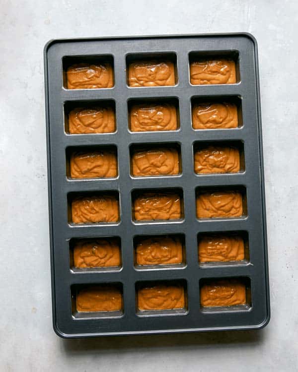 Pumpkin bar batter poured into a prepared baking sheet.