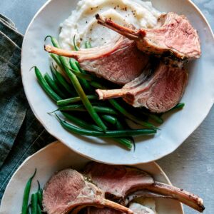Roasted rack of lamb recipe on a plate.