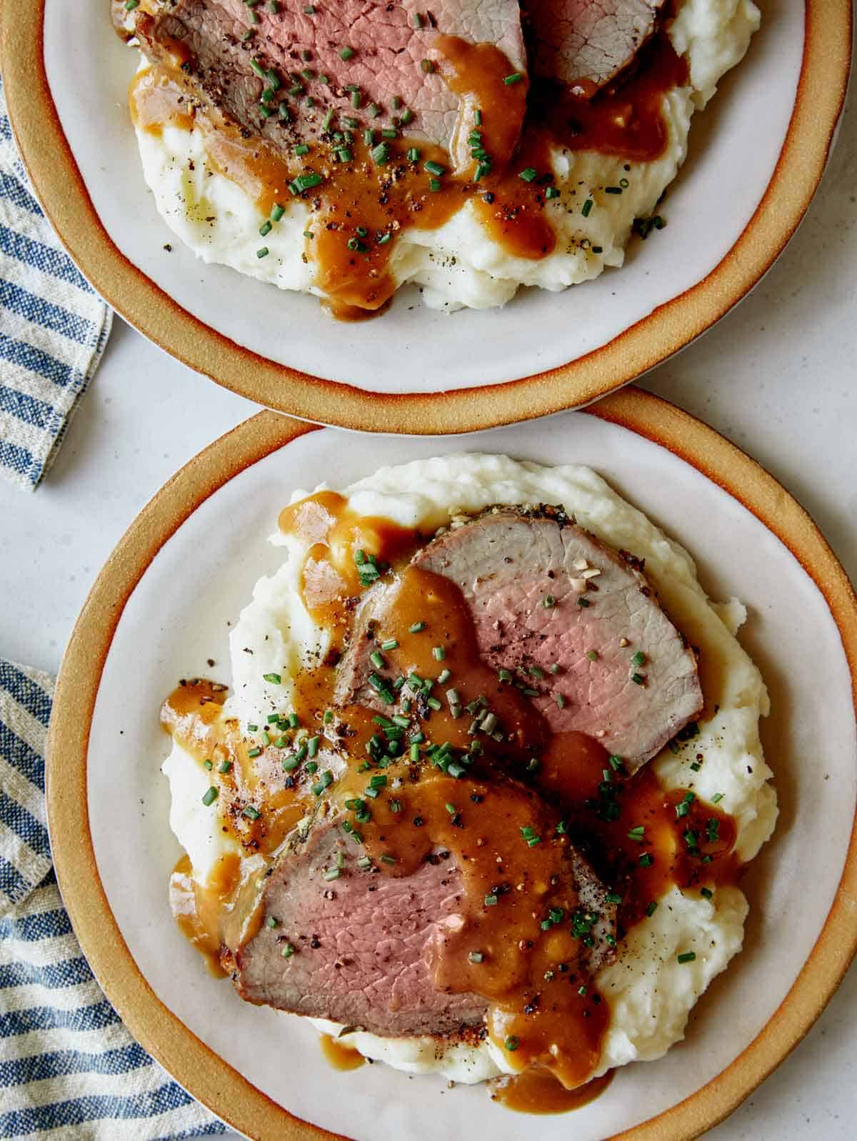 Easy Roast beef recipe plated with gravy and mashed potatoes.