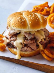 Roast beef sandwich with curly fries on the side.