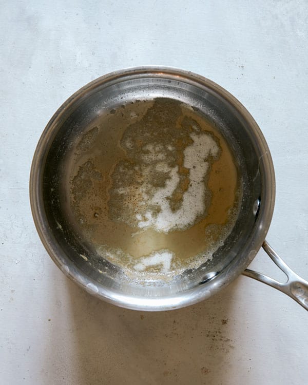 Butter melted in a pot to make a cheese sauce. 