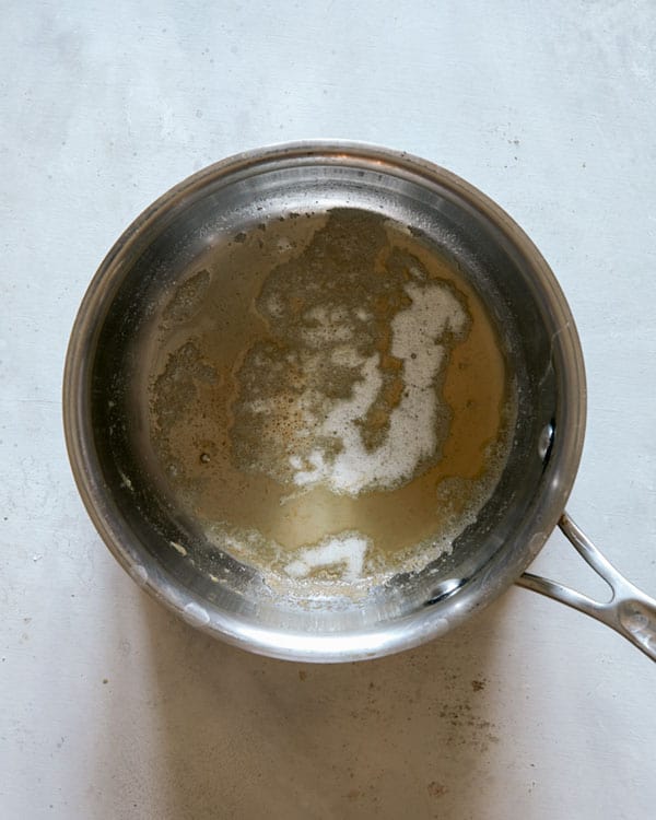 Butter melted in a pot to make a cheese sauce.