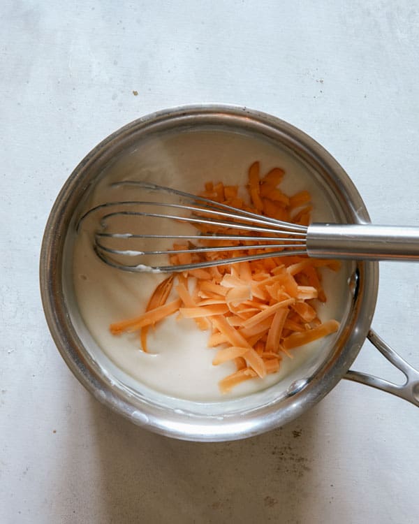 Cheese sauce being made in a pot. 