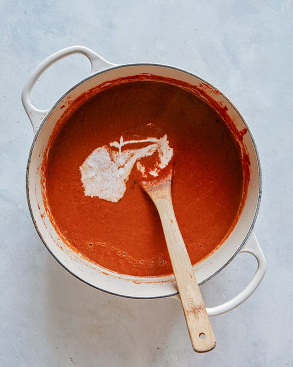 Heavy cream added into a stock pot full of tomato soup.