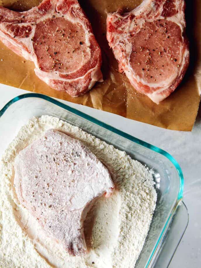 Pork chops being dredged. 