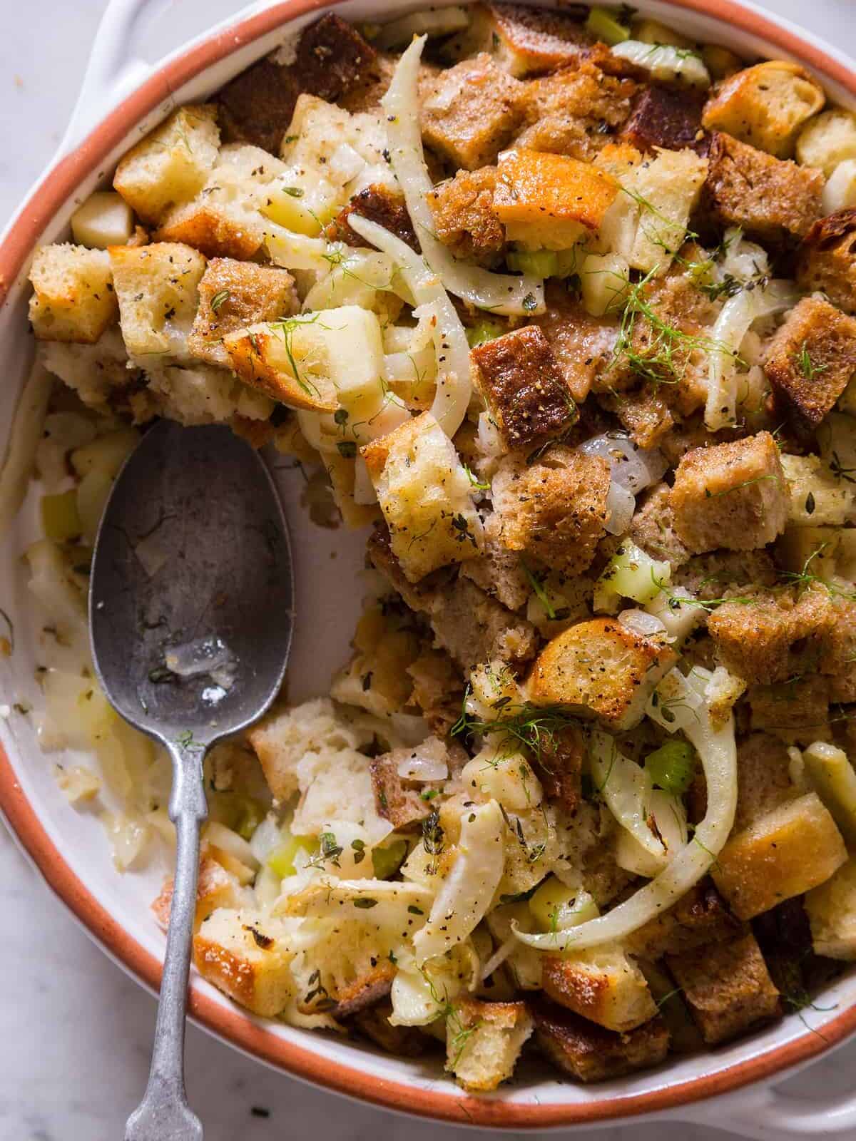 A close up of fennel apple stuffing with a spoon.