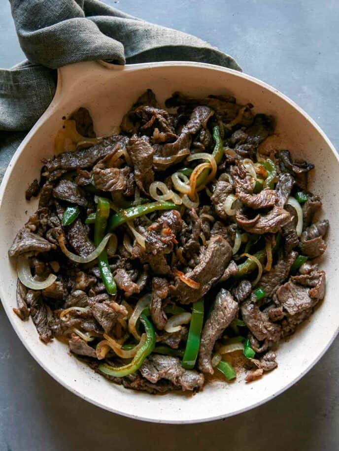 Philly Cheesesteak cooking in a skillet. 