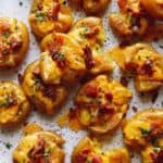Smashed potatoes on a plate.