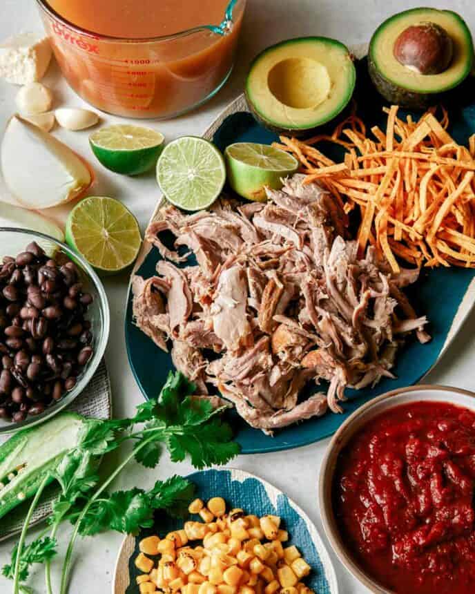 Ingredients to make carnitas tortilla soup recipe in a kitchen.