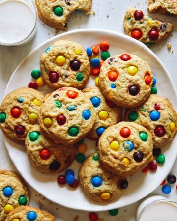 M&M cookie recipe on a plate with milk on the side.