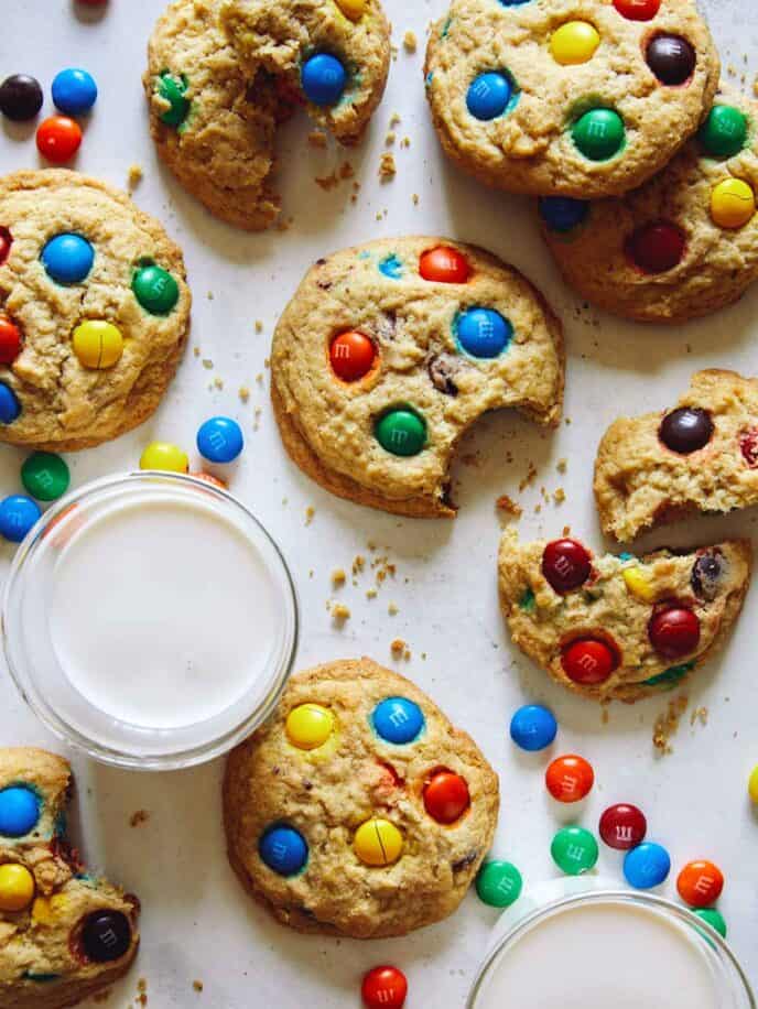M&M cookies being eaten with a glass of milk. 