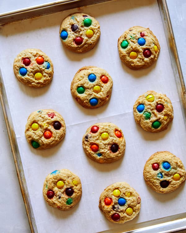 Freshly baked M&M Cookies on a cookie sheet. 