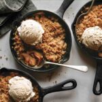 Apple crisps in cast iron skillets being eaten.