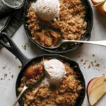 Two apple crisps being eaten.