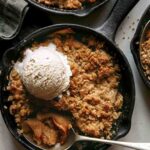 Apple crisp being eaten with ice cream.