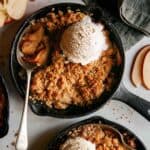 Apple crisps in cast iron skillets being eaten.