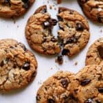 Brown butter chocolate chip cookies with one broken in half.