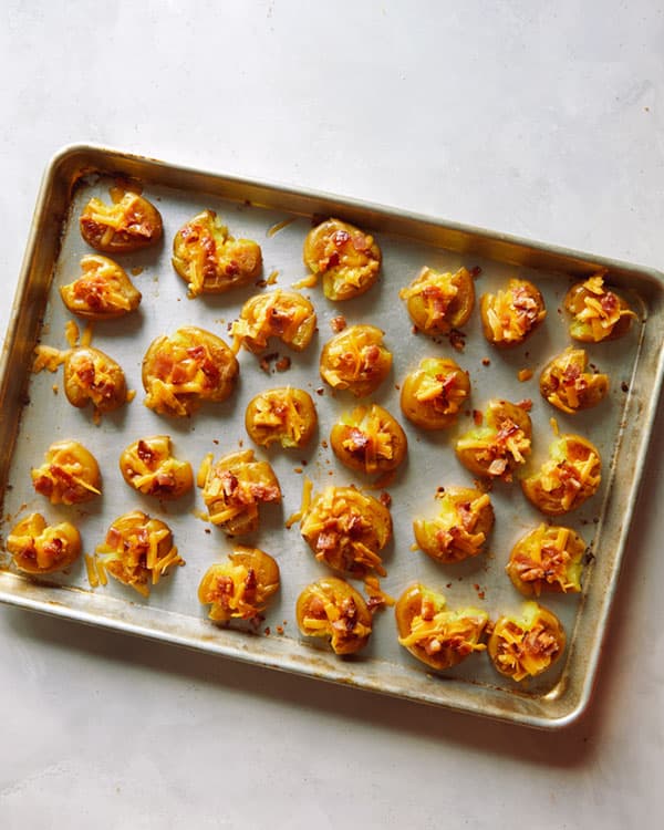 Smashed potatoes topped with cheese and bacon.