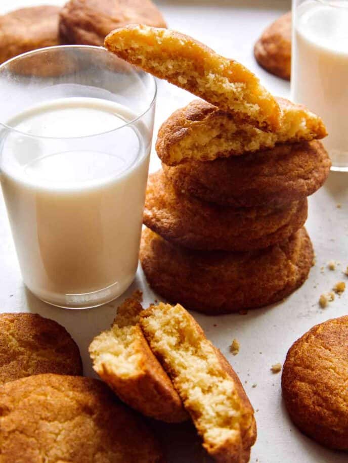 Snickerdoodle cookies snacked next to a glass of milk.