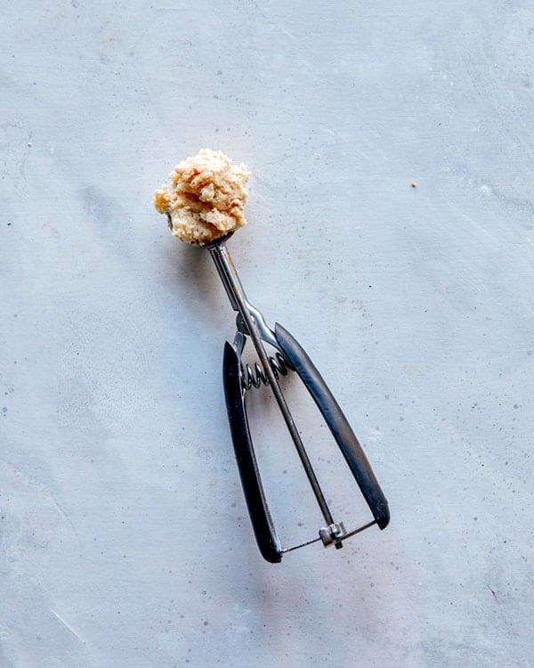 Snickerdoodle dough being scooped.